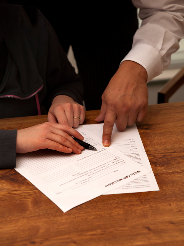 Person signing a Will as part of their estate planning